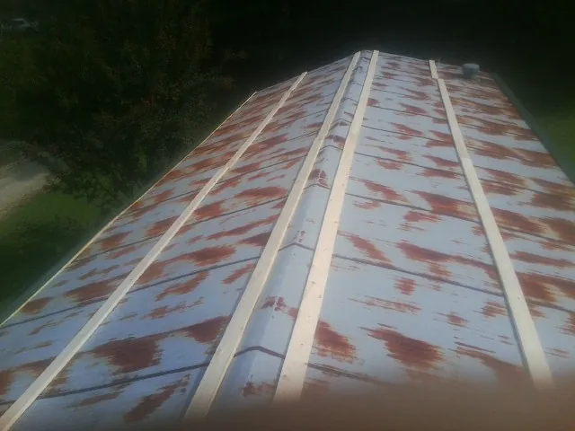 Rusted metal roof panels with new wood purlins before replacement — Storm Damage Roof Repair in Goddard by Roofing Brothers