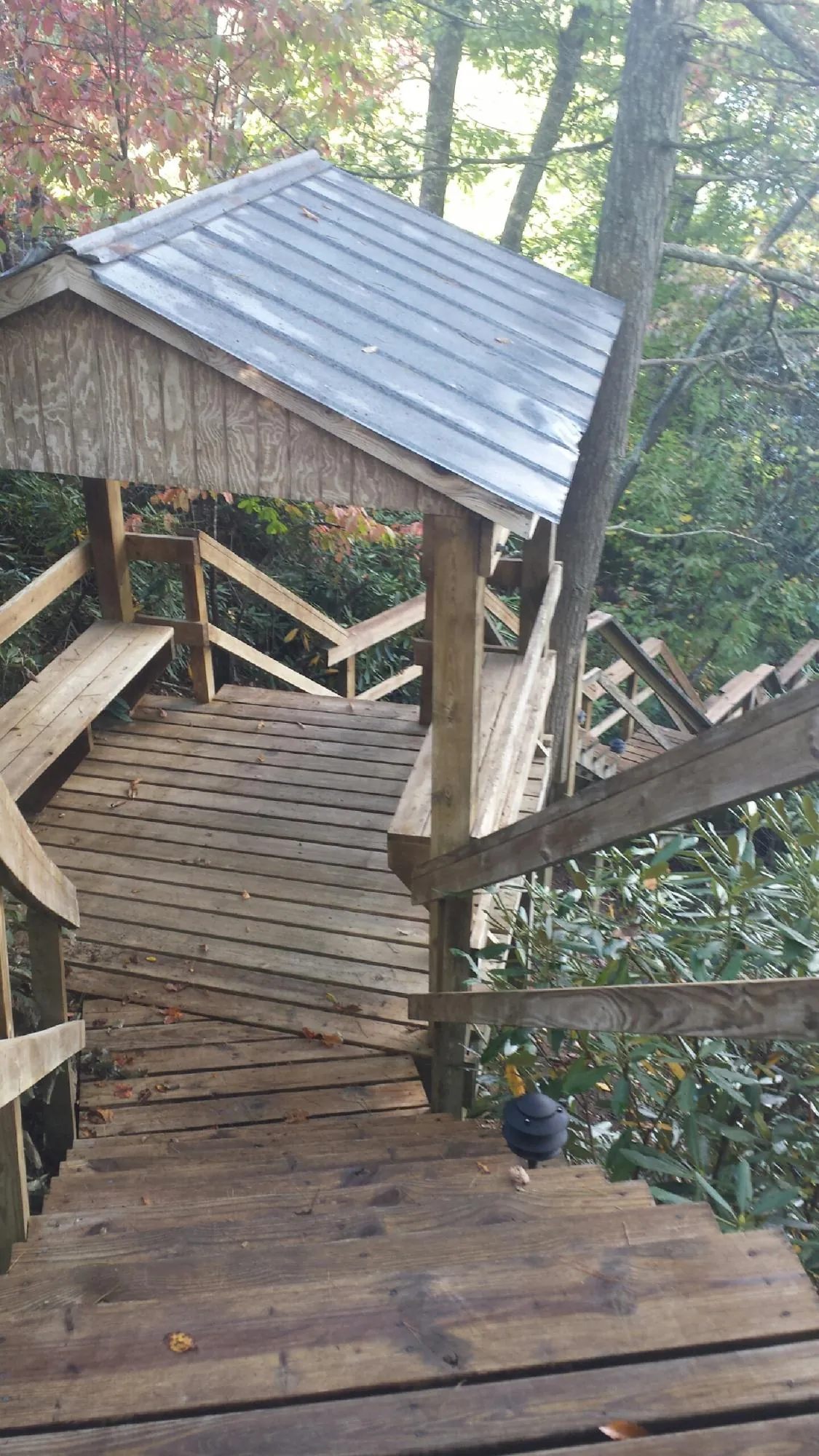Metal roofed shelter over wooden steps on a wooded walkway — Skylight Repair & Installation work by our crew in Goddard