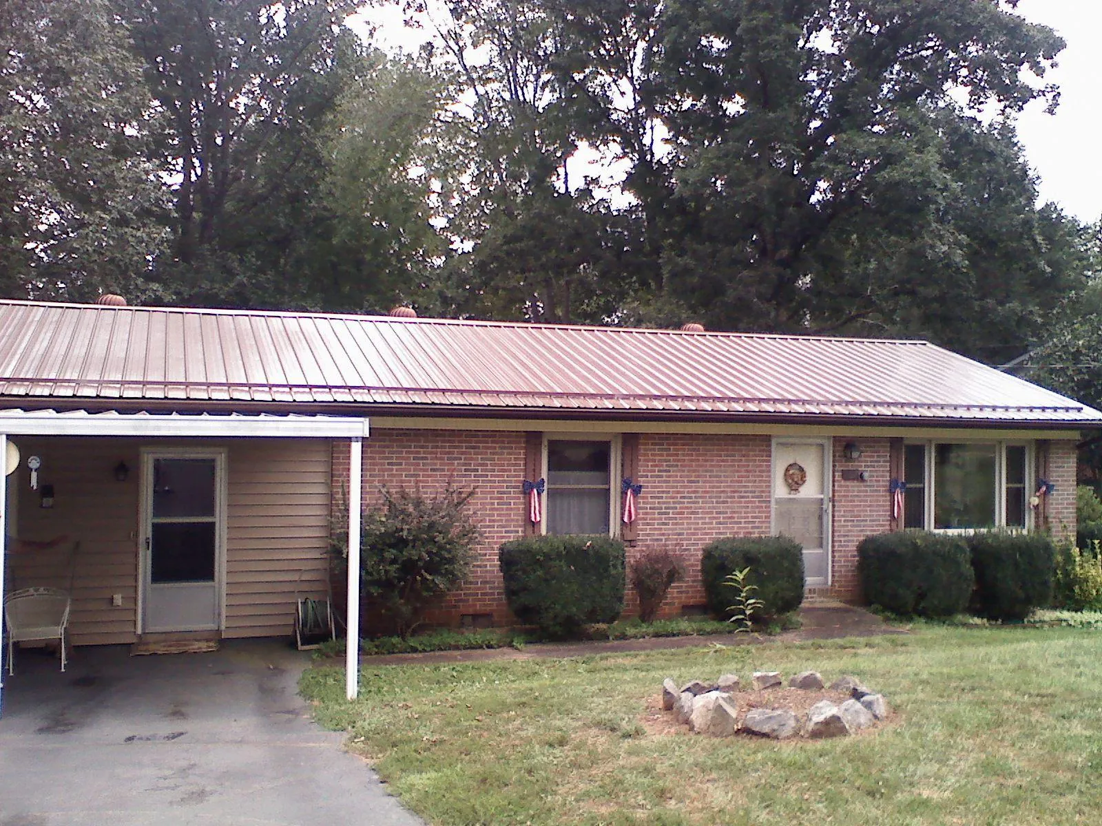 Bronze metal roof and carport on a brick ranch home — Roof Repair work by our crew in Goddard